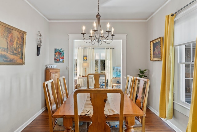 dining area featuring an inviting chandelier, ornamental molding, and dark hardwood / wood-style floors