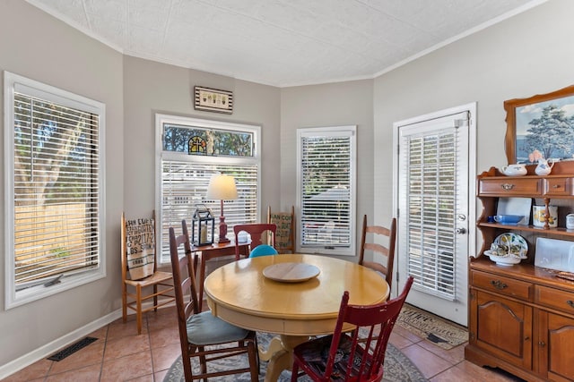 dining area featuring ornamental molding and light tile patterned floors