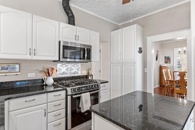 kitchen featuring white cabinetry, appliances with stainless steel finishes, and dark stone counters