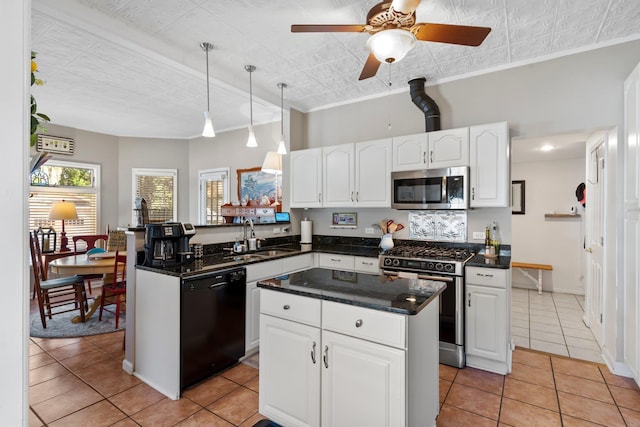 kitchen with sink, a center island, light tile patterned floors, appliances with stainless steel finishes, and white cabinets