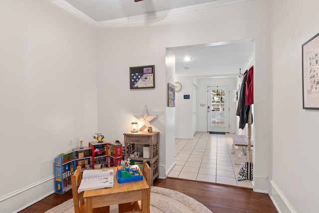 recreation room featuring hardwood / wood-style floors and crown molding