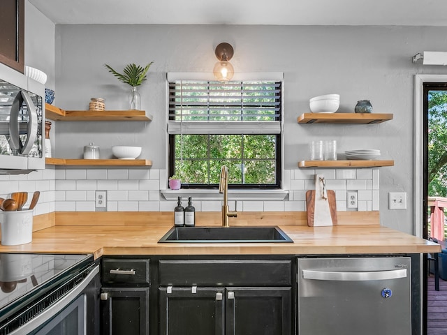 420 Indian Village Trl, Tallahassee, FL 32304 - kitchen featuring appliances with stainless steel finishes, a sink, butcher block counters, dark cabinets, and open shelves