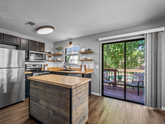 420 Indian Village Trl, Tallahassee, FL 32304 - kitchen with butcher block counters, appliances with stainless steel finishes, a sink, open shelves, and wood finished floors