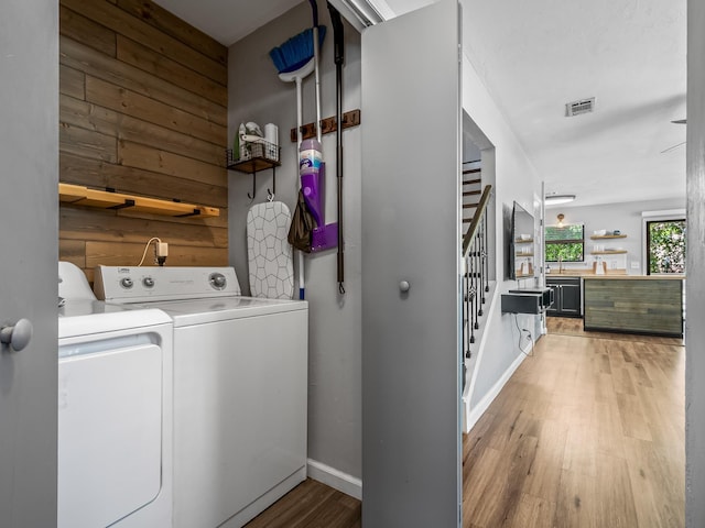 420 Indian Village Trl, Tallahassee, FL 32304 - laundry area featuring separate washer and dryer, light wood finished floors, wooden walls, and baseboards