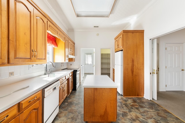 kitchen with ornamental molding, a kitchen island, sink, white appliances, and dark colored carpet