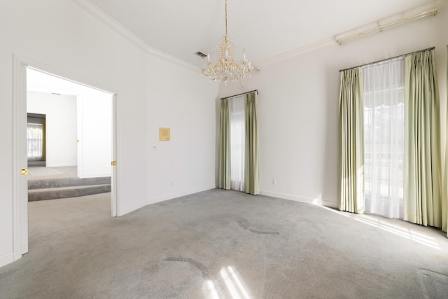 carpeted spare room featuring ornamental molding and a chandelier