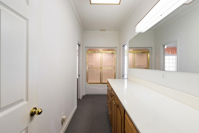 bathroom with bath / shower combo with glass door, vanity, and crown molding