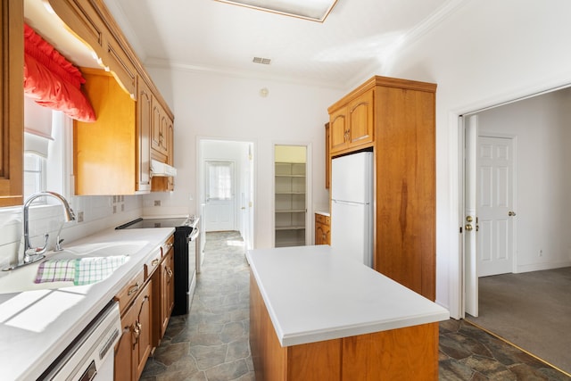 kitchen featuring white refrigerator, exhaust hood, sink, a healthy amount of sunlight, and a center island