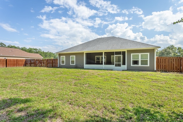 back of house with a sunroom and a lawn