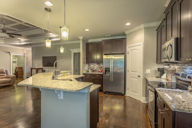 kitchen with stainless steel appliances, dark wood-type flooring, sink, and decorative light fixtures