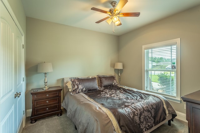 bedroom featuring a closet, light colored carpet, and ceiling fan