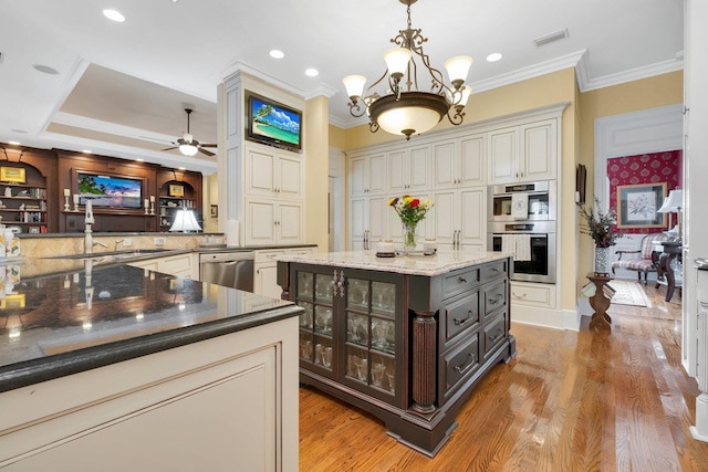 kitchen with pendant lighting, appliances with stainless steel finishes, dark stone countertops, dark brown cabinets, and a center island with sink