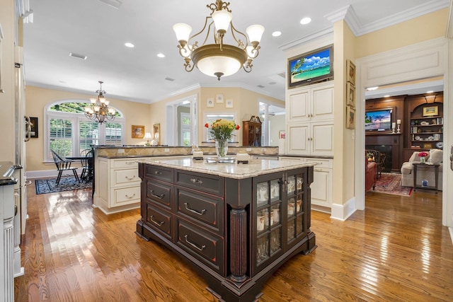 kitchen featuring hardwood / wood-style flooring, a kitchen island, dark brown cabinets, and a notable chandelier