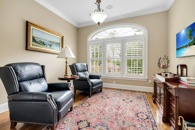 sitting room with ornamental molding and light hardwood / wood-style floors