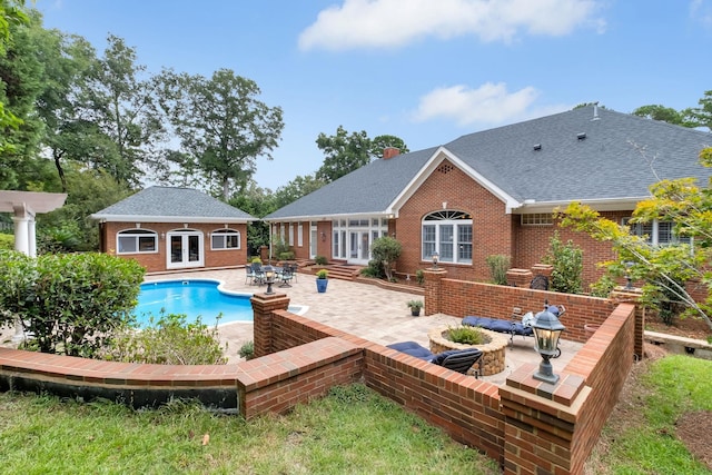 view of pool featuring a patio area, an outdoor structure, and french doors