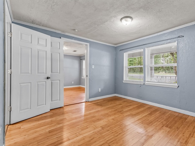 1487 Bainbridge Hwy, Quincy, FL 32352 - unfurnished bedroom with crown molding, a textured ceiling, and light wood finished floors