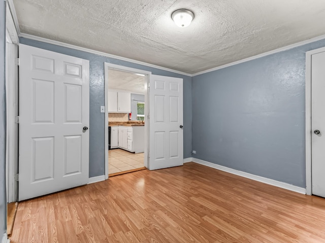 1487 Bainbridge Hwy, Quincy, FL 32352 - unfurnished bedroom with ornamental molding, light wood-style floors, a textured ceiling, and ensuite bath