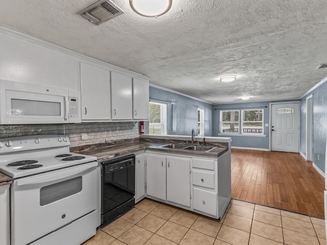 1487 Bainbridge Hwy, Quincy, FL 32352 - kitchen with white appliances, white cabinets, dark countertops, a peninsula, and decorative backsplash