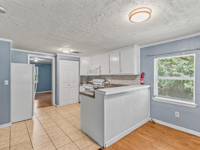 1487 Bainbridge Hwy, Quincy, FL 32352 - kitchen with white appliances, white cabinetry, tasteful backsplash, ornamental molding, and a peninsula