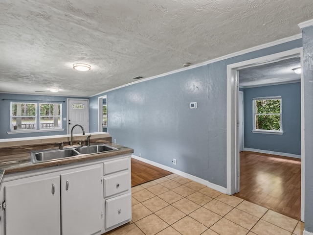 1487 Bainbridge Hwy, Quincy, FL 32352 - kitchen with ornamental molding, white cabinetry, light tile patterned floors, and a textured ceiling