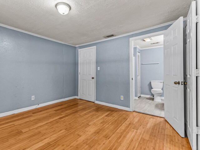 1487 Bainbridge Hwy, Quincy, FL 32352 - unfurnished bedroom with light wood-type flooring, ornamental molding, a textured ceiling, and ensuite bathroom