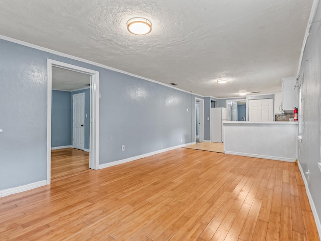 1487 Bainbridge Hwy, Quincy, FL 32352 - unfurnished living room featuring light wood-style floors, ornamental molding, and a textured ceiling