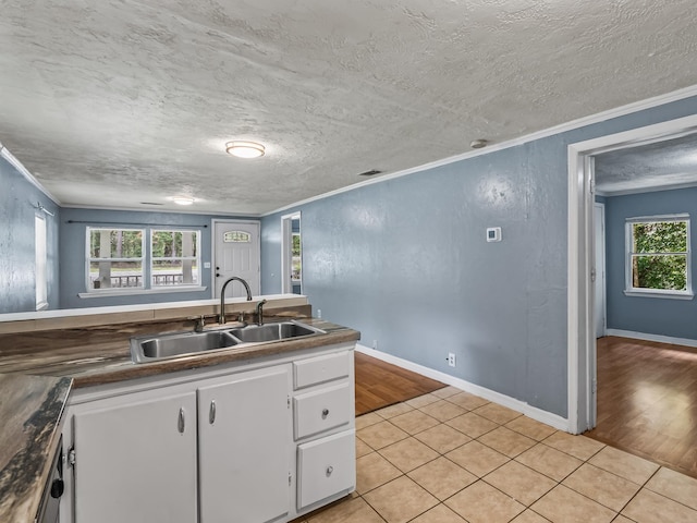 1487 Bainbridge Hwy, Quincy, FL 32352 - kitchen featuring crown molding, white cabinetry, light tile patterned floors, a textured ceiling, and dark countertops