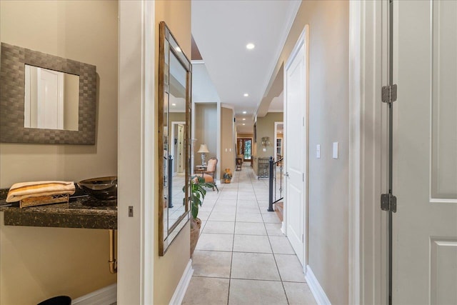 hall with ornamental molding and light tile patterned floors