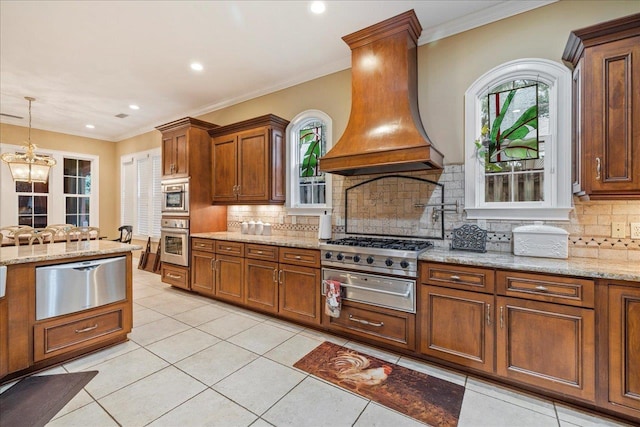 kitchen featuring custom exhaust hood, crown molding, decorative light fixtures, oven, and light stone countertops