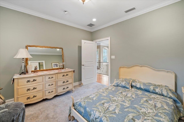 bedroom with ornamental molding and light colored carpet