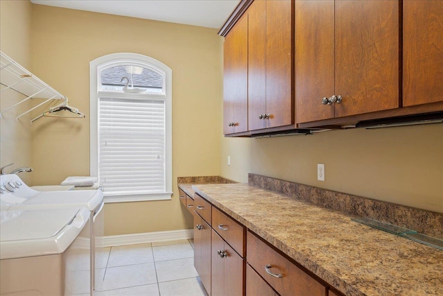 clothes washing area with cabinets, light tile patterned flooring, and independent washer and dryer