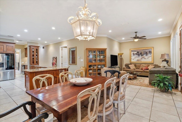 tiled dining area with ceiling fan with notable chandelier and ornamental molding