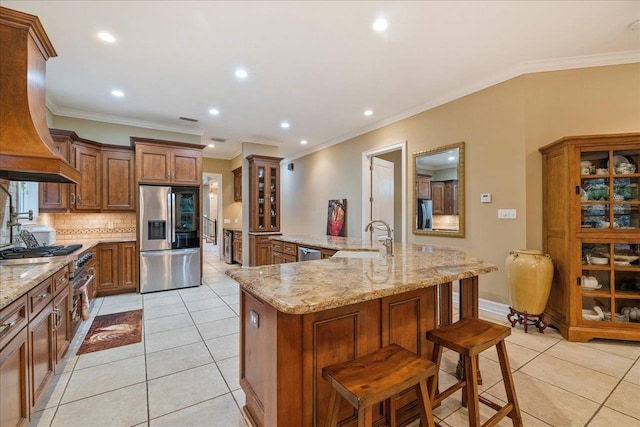 kitchen featuring sink, stainless steel appliances, a spacious island, a kitchen bar, and custom exhaust hood