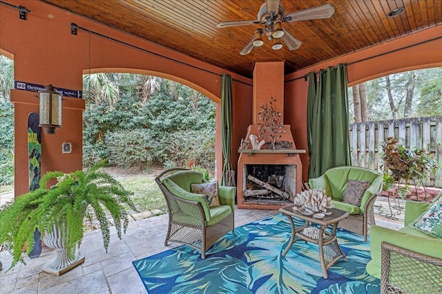 view of patio / terrace with exterior fireplace and ceiling fan