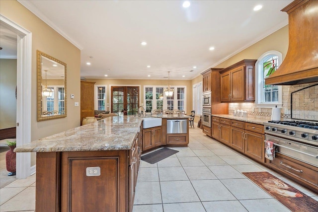 kitchen with premium range hood, crown molding, sink, and a large island with sink