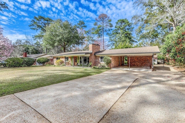 ranch-style home featuring driveway, a chimney, a carport, and a front yard