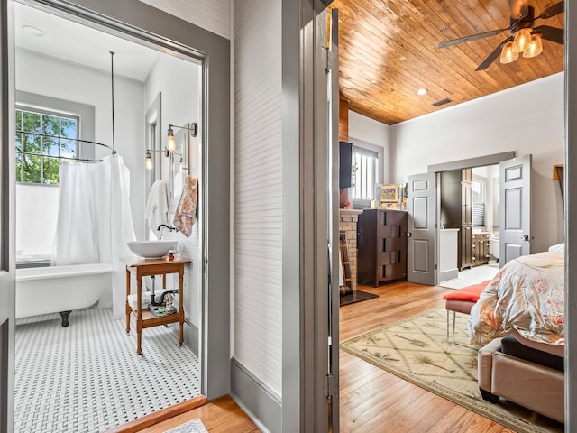 bedroom with multiple windows, light hardwood / wood-style floors, and wooden ceiling