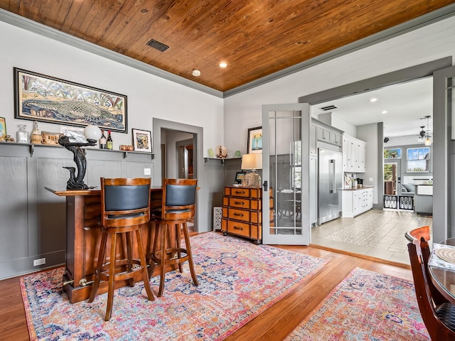 office area featuring wood ceiling, indoor bar, and light wood-type flooring