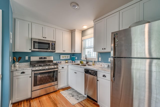 kitchen featuring white cabinetry, appliances with stainless steel finishes, sink, and light hardwood / wood-style floors