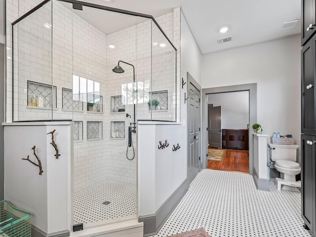 bathroom with toilet and a shower with shower door