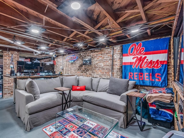 living room featuring brick wall and concrete floors