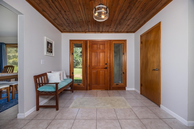 foyer with wooden ceiling, light tile patterned floors, and crown molding