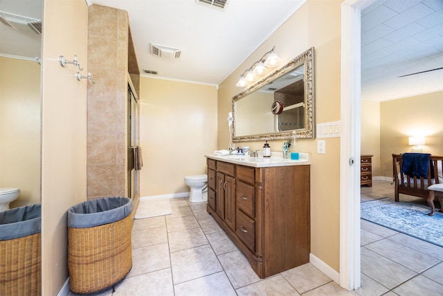 bathroom with toilet, vanity, tile patterned floors, and crown molding