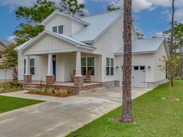 view of front of home featuring a garage, covered porch, and a front lawn