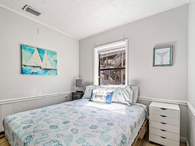 bedroom featuring ornamental molding and a textured ceiling