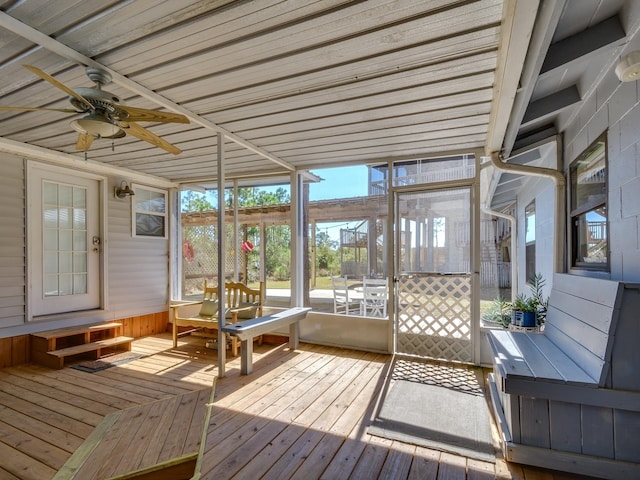 unfurnished sunroom featuring ceiling fan