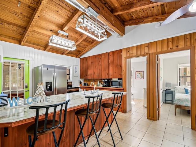 kitchen featuring lofted ceiling with beams, sink, light tile patterned floors, wood ceiling, and stainless steel appliances