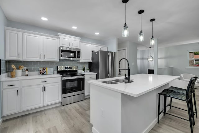 kitchen featuring an island with sink, white cabinets, appliances with stainless steel finishes, and sink