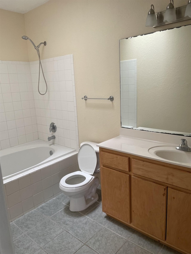 full bathroom with tile patterned flooring, tiled shower / bath combo, toilet, and vanity