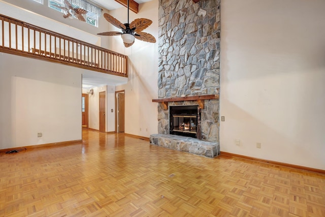 414 Tharpe Cir, Quincy, FL 32351 - unfurnished living room with a towering ceiling, baseboards, ceiling fan, and a stone fireplace